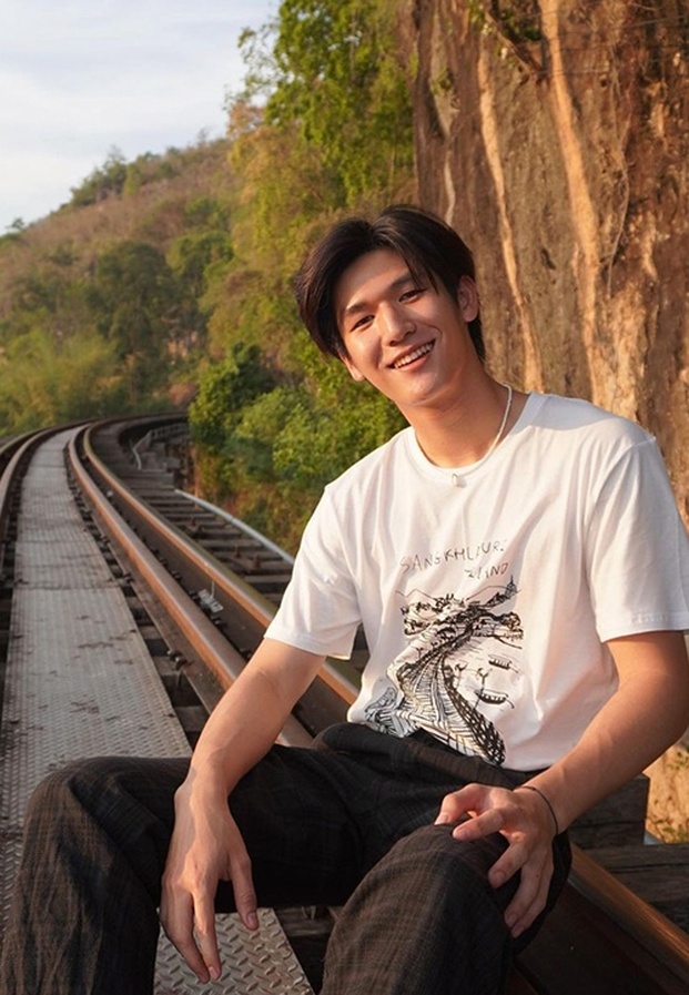 Mos Panuwat (มอส ภาณุวัฒน์) นั่งชิลริมรางรถไฟยามเย็น แสงแดดอุ่นกับรอยยิ้มกระชากใจ